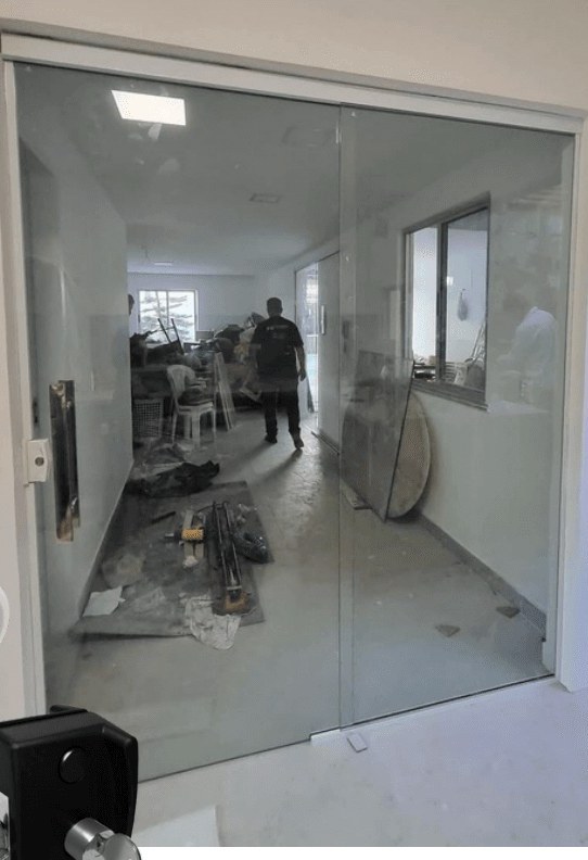 Porta de vidro de duas folhas instalada em obra em andamento