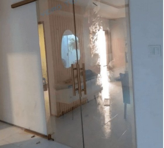Porta de duas folhas de vidro que se recolhem por trás da parede