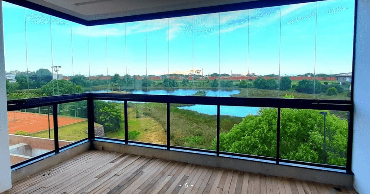 Cortina de vidro fechando uma varanda com vista para o lago